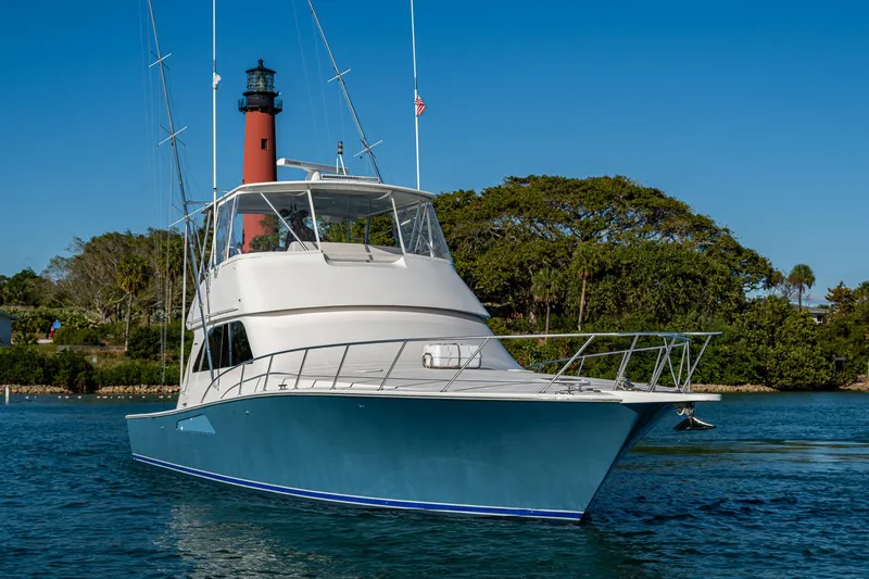 Slide: The Image of 2005 Viking 52 Convertible yacht on water near lighthouse and trees. - 9