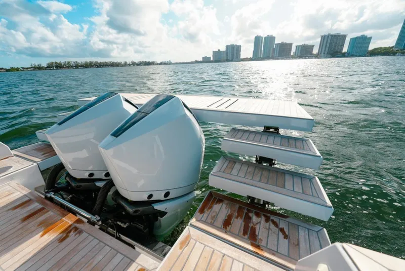 Slide: The Image of 2022 Tesoro T40 Outboard boat with dual engines and wooden deck, overlooking city skyline. - 10