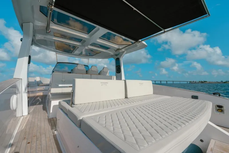 Slide: The Image of 2022 Tesoro T40 Outboard boat with luxurious seating and canopy on a sunny day. - 14