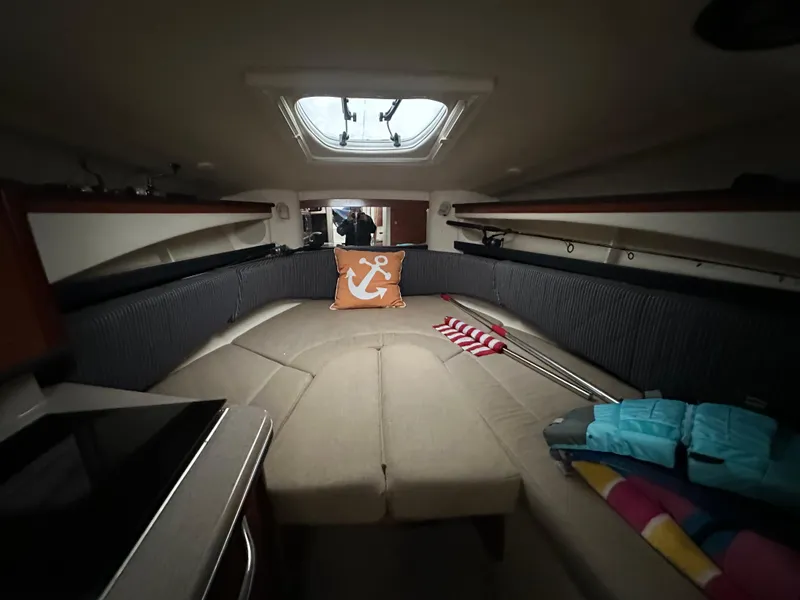 Slide: The Image of 2005 Sea Ray 260 Sundancer cabin interior with cozy seating and nautical decor. - 6