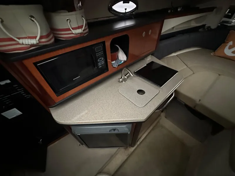Slide: The Image of Interior of 2005 Sea Ray 260 Sundancer with kitchenette, microwave, sink, and seating area. - 7