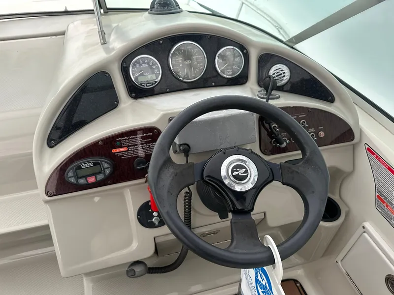 Slide: The Image of Dashboard of a 2005 Sea Ray 260 Sundancer boat with steering wheel and gauges. - 9