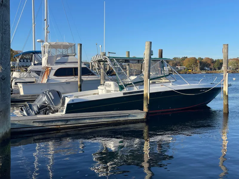 The Image of 1999 Contender 35 Express Side Console boat docked in a marina. - 0