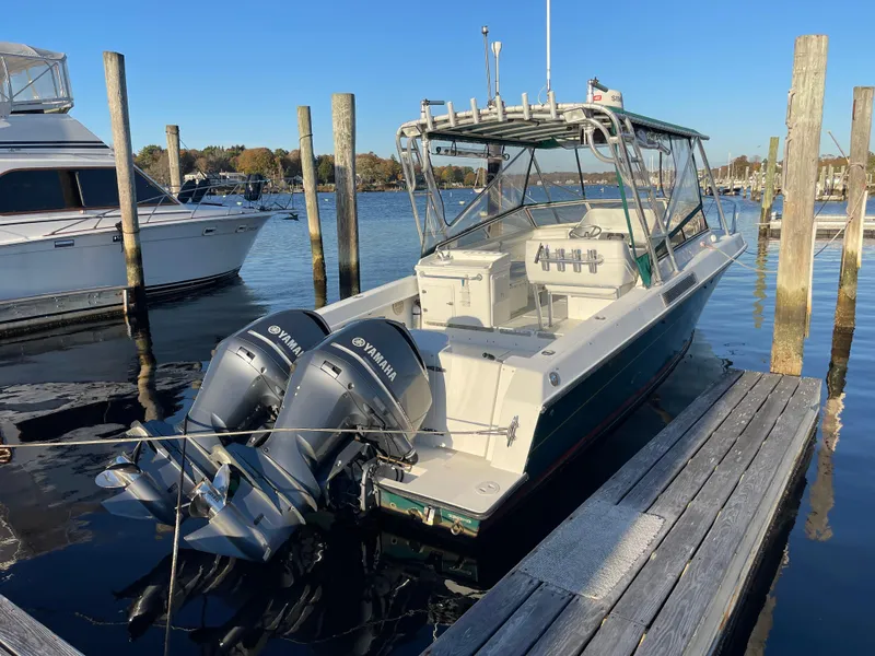 Slide: The Image of 1999 Contender 35 Express Side Console boat docked with twin Yamaha engines. - 1