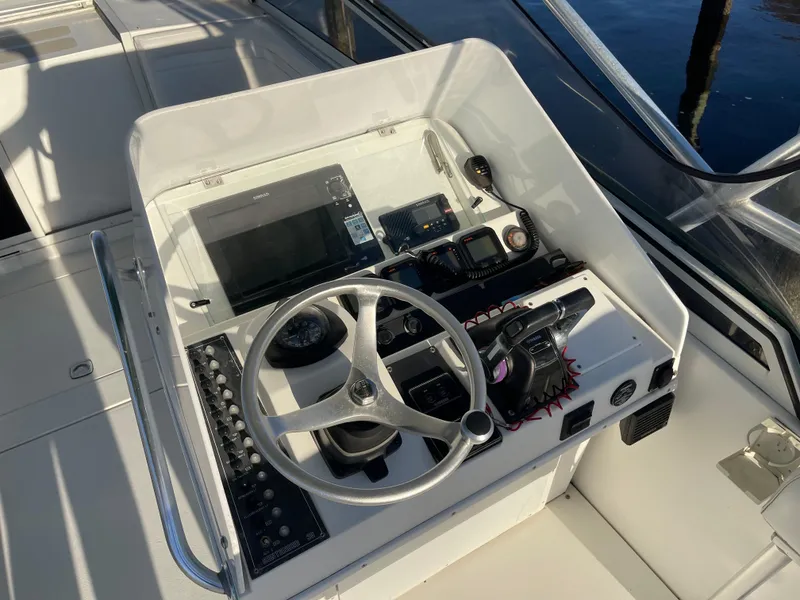 Slide: The Image of 1999 Contender 35 Express Side Console helm with steering wheel and navigation equipment. - 12