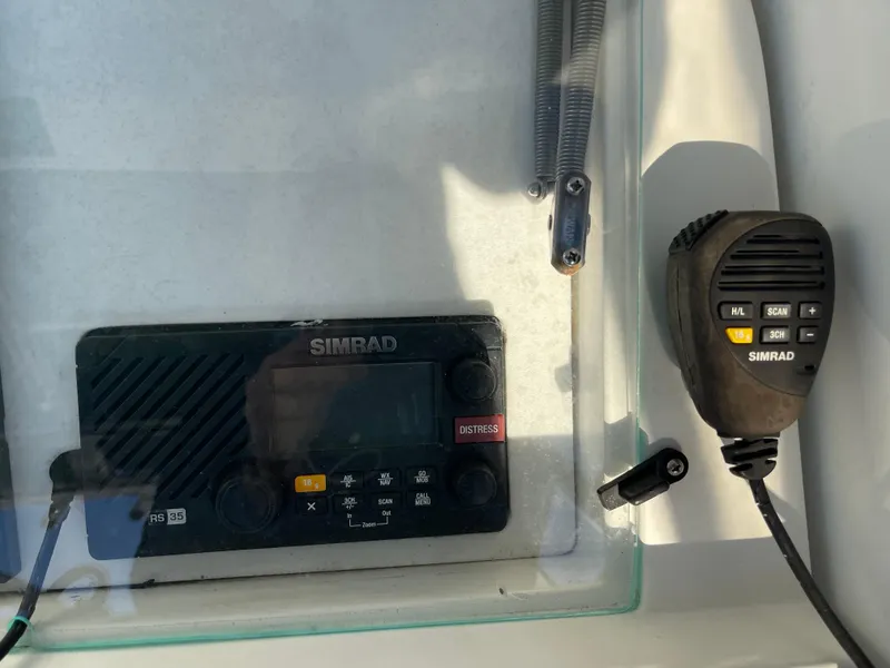 Slide: The Image of Simrad marine radio and microphone on 1999 Contender 35 Express Side Console. - 13