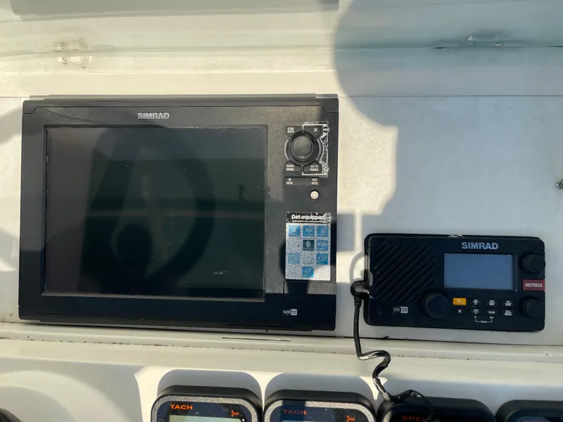 Slide: The Image of Simrad marine electronics on 1999 Contender 35 Express Side Console boat dashboard. - 14