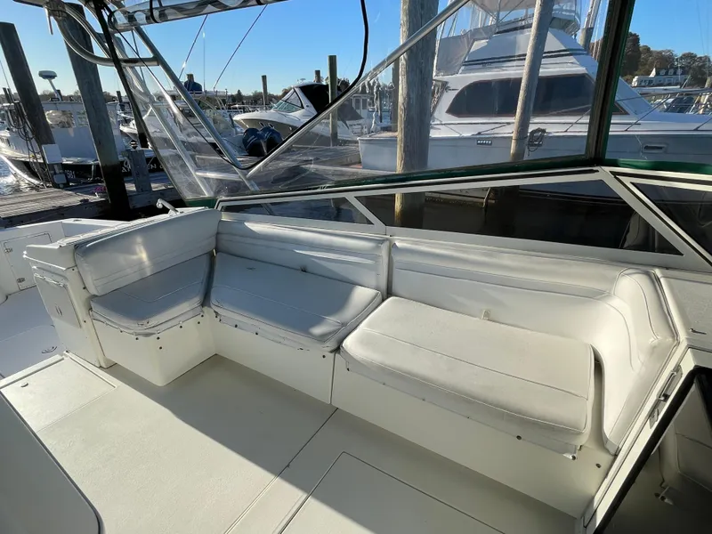 Slide: The Image of 1999 Contender 35 Express Side Console with white seating, docked at a marina. - 19