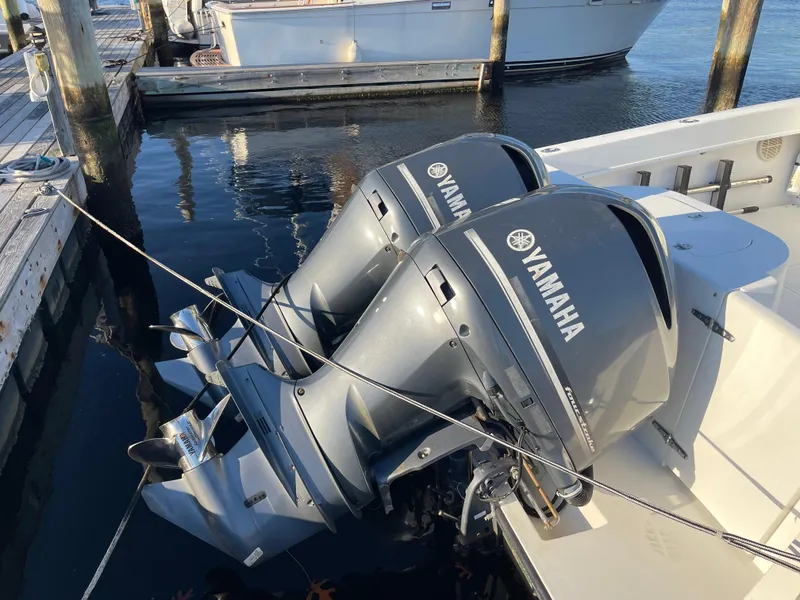 Slide: The Image of Twin Yamaha outboard motors on a 1999 Contender 35 Express Side Console boat at a dock. - 2