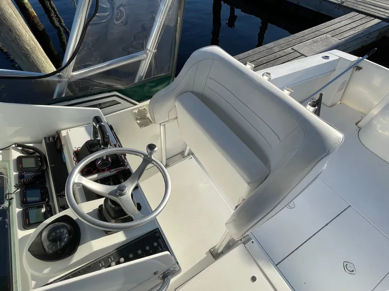 Slide: The Image of 1999 Contender 35 Express Side Console boat interior with steering wheel and seating. - 21