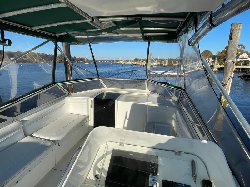 Slide: The Image of 1999 Contender 35 Express Side Console boat interior with clear canopy and waterfront view. - 22