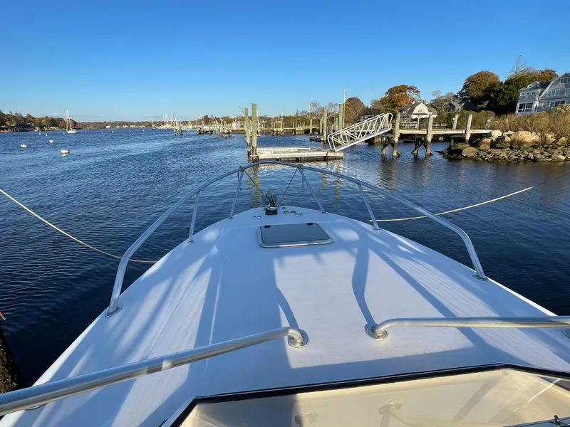 Slide: The Image of 1999 Contender 35 Express Side Console boat docked in a scenic marina. - 26