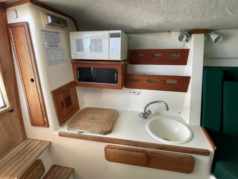 Slide: The Image of Compact kitchen area in a 1999 Contender 35 Express Side Console boat. - 29