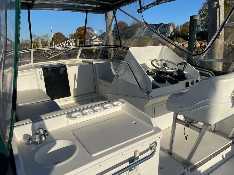 Slide: The Image of 1999 Contender 35 Express Side Console boat interior with steering wheel and seating area. - 3