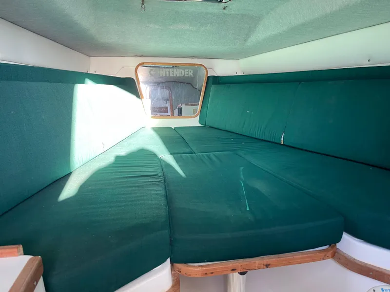 Slide: The Image of 1999 Contender 35 Express Side Console cabin with green cushioned seating. - 30