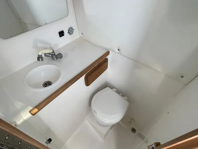 Slide: The Image of 1999 Contender 35 Express Side Console boat bathroom with sink, toilet, and mirror. - 37