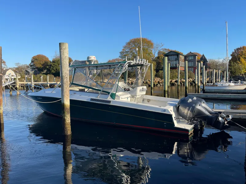 Slide: The Image of 1999 Contender 35 Express Side Console boat docked in a serene marina setting. - 6