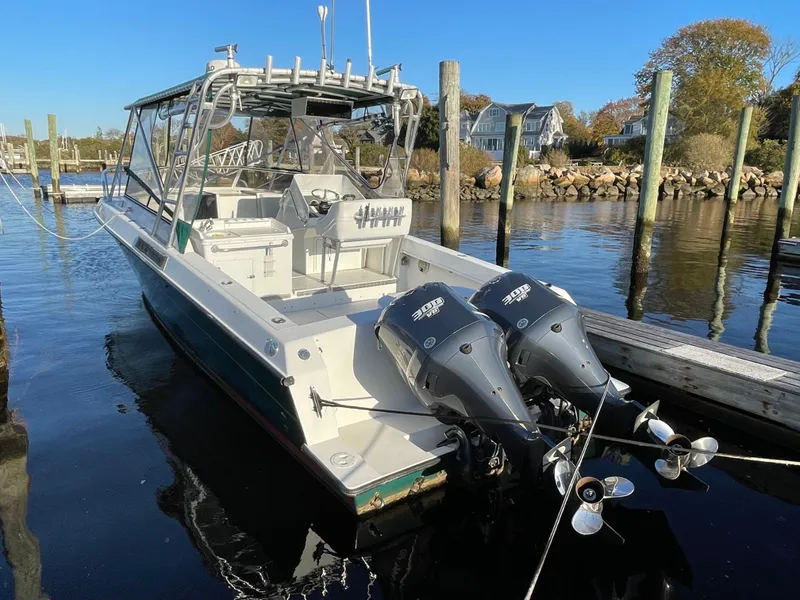 Slide: The Image of 1999 Contender 35 Express Side Console boat docked with twin outboard engines. - 7