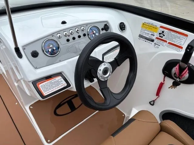 Slide: The Image of 2025 Tahoe 185 S boat dashboard with steering wheel and control panel. - 11