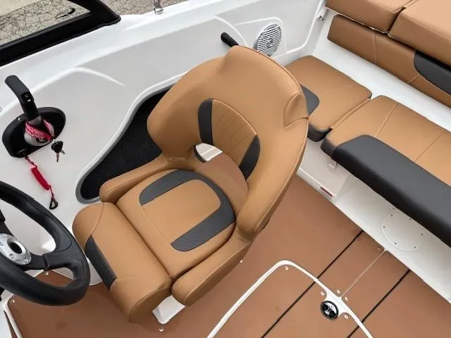 Slide: The Image of 2025 Tahoe 185 S boat interior with tan and black seating, steering wheel, and speaker. - 12