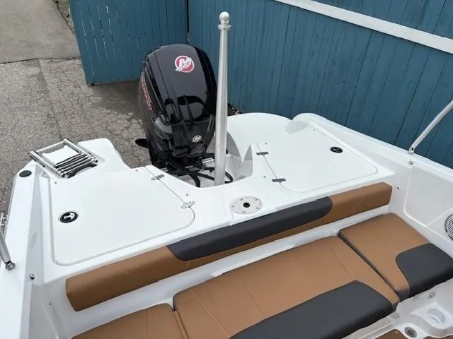 Slide: The Image of 2025 Tahoe 185 S boat with outboard motor and tan seating, docked by blue fence. - 18