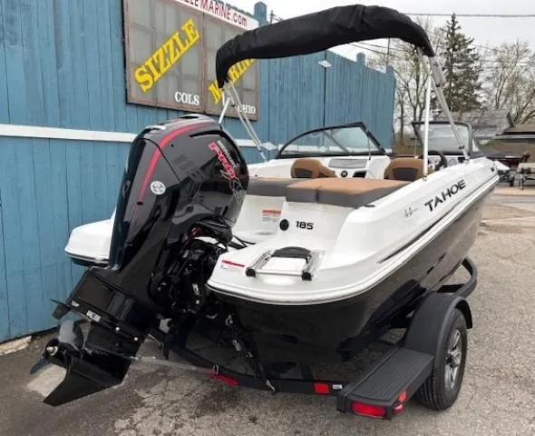 Slide: The Image of 2025 Tahoe 185 S boat with outboard motor on trailer, parked near blue building. - 3