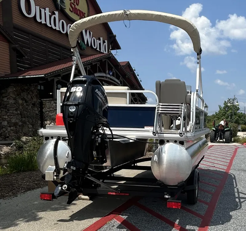 Slide: The Image of 2025 Sun Tracker Bass Buggy 16 XL Select pontoon boat outside Outdoor World store. - 4