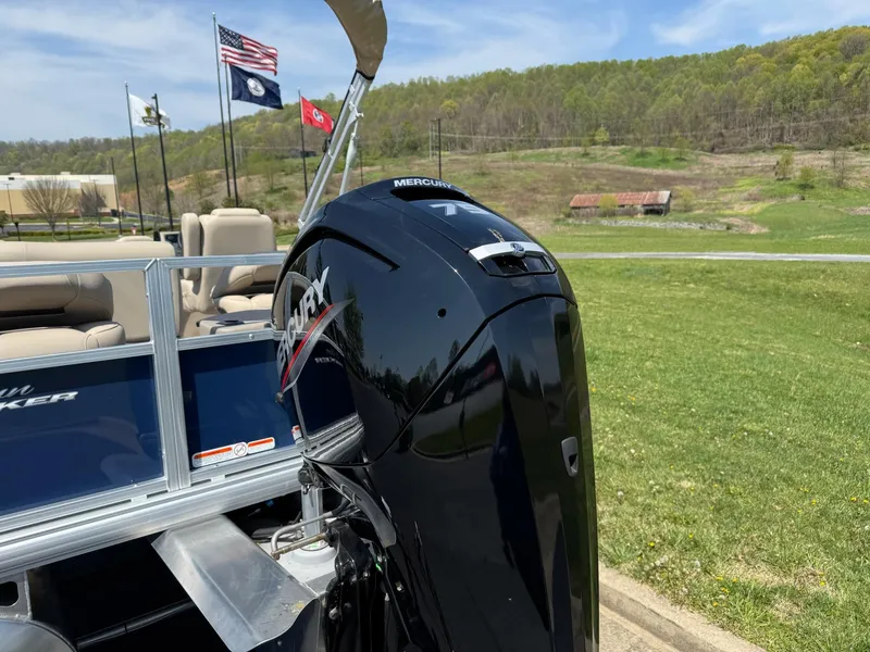 Slide: The Image of 2025 Sun Tracker Bass Buggy 18 DLX with Mercury outboard motor, flags in background. - 6