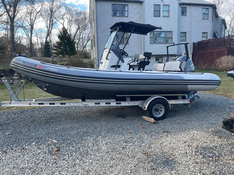 Slide: The Image of 2020 Zodiac Open 6.5 boat on trailer in residential driveway. - 2
