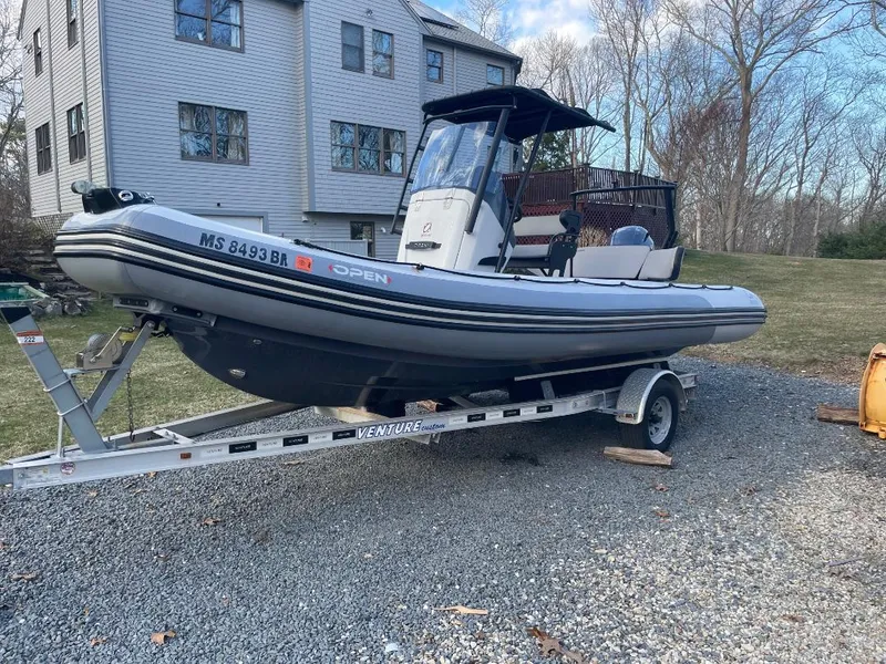 Slide: The Image of 2020 Zodiac Open 6.5 boat on trailer, parked outdoors near a house. - 3