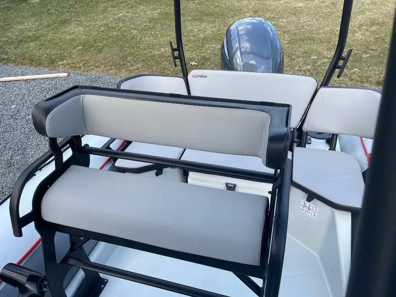 Slide: The Image of 2020 Zodiac Open 6.5 boat interior with seating and motor, outdoor setting. - 7