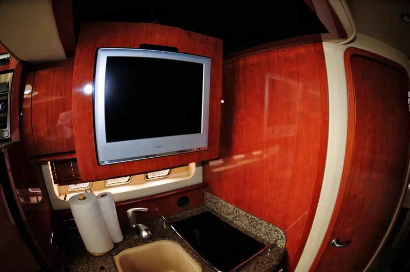 Slide: The Image of Interior of 2006 Sea Ray 380 Sundancer yacht with TV, sink, and wooden cabinetry. - 11
