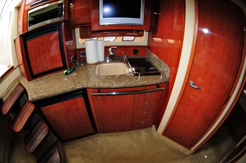 Slide: The Image of Luxurious kitchen interior of 2006 Sea Ray 380 Sundancer yacht with wood cabinetry. - 13