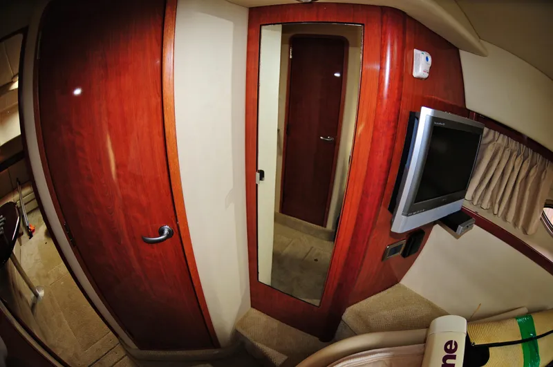 Slide: The Image of Interior of 2006 Sea Ray 380 Sundancer with wood paneling and mounted TV. - 15