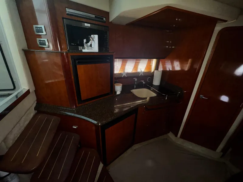 Slide: The Image of Interior of 2006 Sea Ray 380 Sundancer yacht with kitchenette and wooden cabinetry. - 18