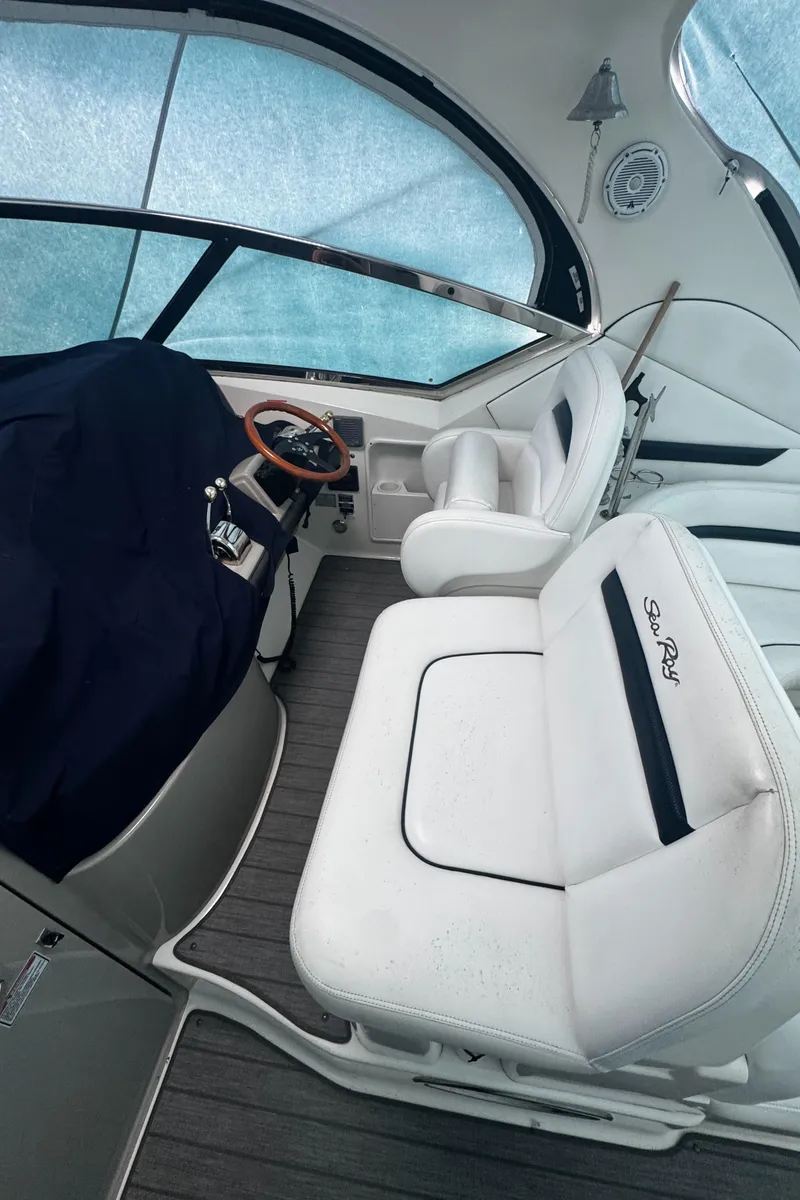 Slide: The Image of 2006 Sea Ray 380 Sundancer cockpit with white seating and covered helm. - 4