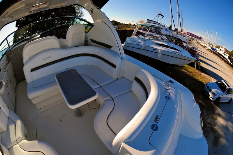 Slide: The Image of 2006 Sea Ray 380 Sundancer yacht interior with seating and table, docked near other boats. - 5