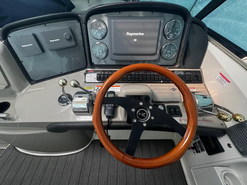 Slide: The Image of 2006 Sea Ray 380 Sundancer helm with Raymarine display and wooden steering wheel. - 8