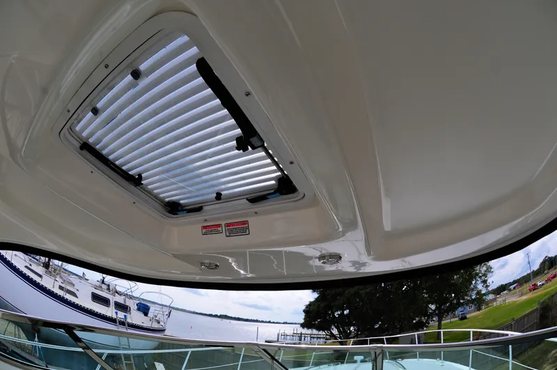Slide: The Image of 2006 Sea Ray 380 Sundancer sunroof view with marina and trees in the background. - 9