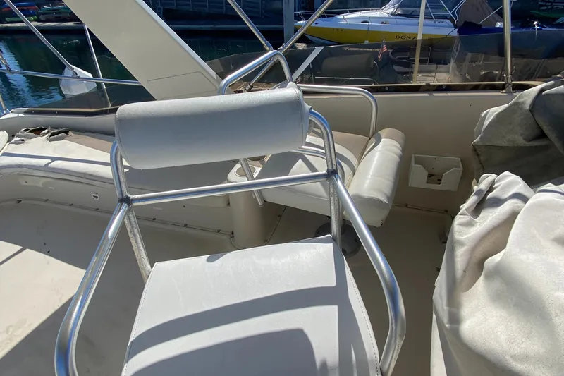 Slide: The Image of 1991 Mainship 41 Convertible boat interior with white seating and metal frames. - 10