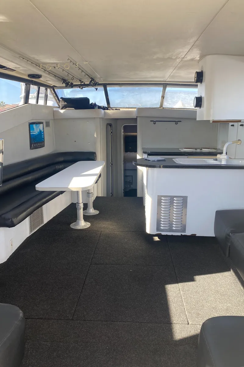 Slide: The Image of Interior of 1991 Mainship 41 Convertible yacht with seating, table, and kitchenette. - 12