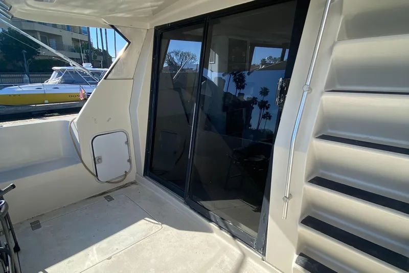 Slide: The Image of 1991 Mainship 41 Convertible yacht deck with sliding glass doors and stairs. - 13