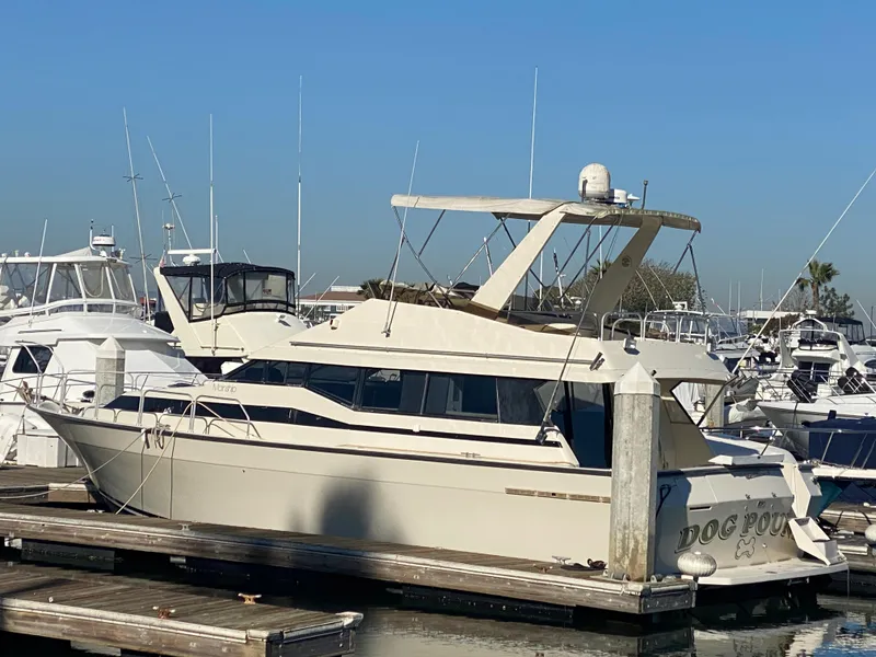 Slide: The Image of 1991 Mainship 41 Convertible yacht docked at marina under clear blue sky. - 2