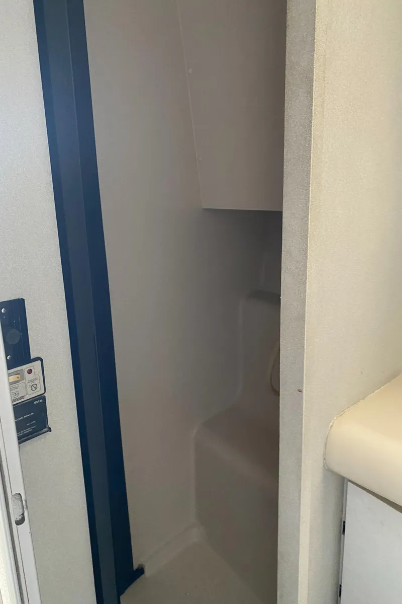 Slide: The Image of Interior view of a 1991 Mainship 41 Convertible boat, featuring a compact shower area. - 23