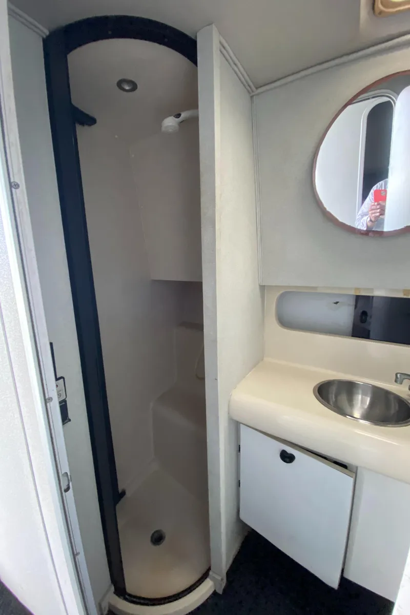 Slide: The Image of 1991 Mainship 41 Convertible bathroom with compact shower, sink, and mirror. - 24