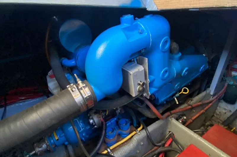 Slide: The Image of Engine compartment of a 1991 Mainship 41 Convertible boat, featuring blue components and hoses. - 28