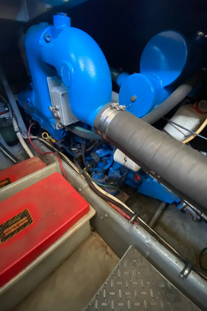 Slide: The Image of Engine room of 1991 Mainship 41 Convertible with blue machinery and red battery box. - 29