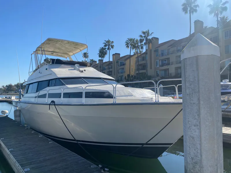 Slide: The Image of 1991 Mainship 41 Convertible yacht docked at marina, sunny day, palm trees in background. - 3