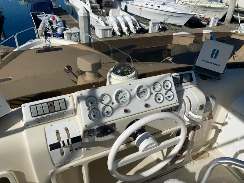 Slide: The Image of 1991 Mainship 41 Convertible yacht helm with gauges and steering wheel at marina. - 5