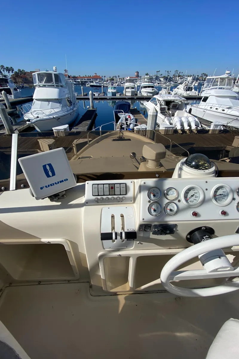Slide: The Image of 1991 Mainship 41 Convertible yacht dashboard with marina view, featuring navigation instruments. - 9